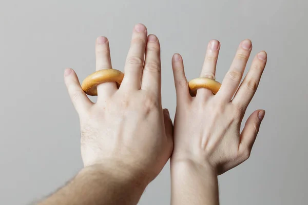 joke photo. hands of the newlyweds. bagels instead of rings. fun wedding concept