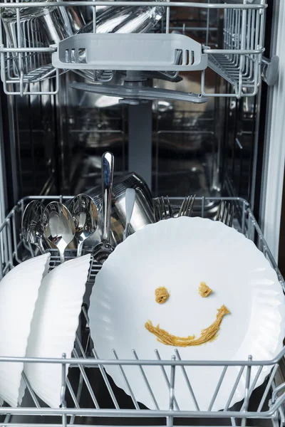 perfectly washed dishes in the dishwasher. Joyful smile on a plate