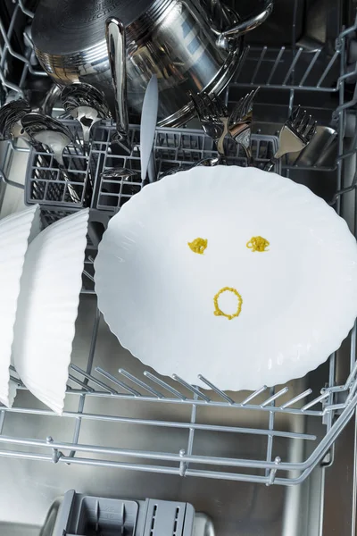 well-washed dishes in the dishwasher. a surprised emotion is depicted on a plate