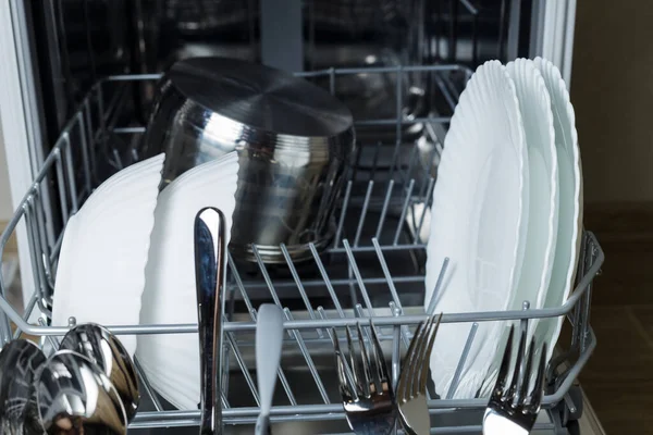 Bulaşık makinesinde çorba tabakları, tencere ve spagetti tabakları var. Dolu bulaşık makinesi. İyice yıkanmış mutfak aletleri.