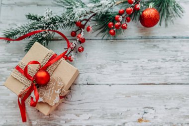 Tahta bir arka planda kar taneleriyle hediye kutusu ve Noel süslemeleri..