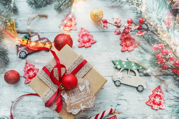 Caja de regalo y decoraciones de Navidad sobre un fondo de madera con copos de nieve y una guirnalda. concepto de año nuevo. — Foto de Stock