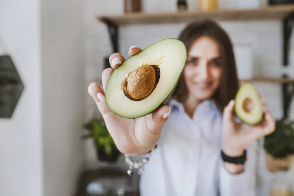 Cut Avocado Halves Hands Happy Young Girl Blurred Background — Stock Photo, Image