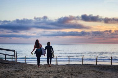 Birkaç gün batımı sörfü. Plajda sörf tahtası olan sörfçüler. Sörf konsepti. Su sporu. 