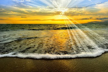 Güneş, Güneş ışınları Okyanus 'un günbatımından kıyıya doğru yumuşak bir dalga gibi süzülüyor.