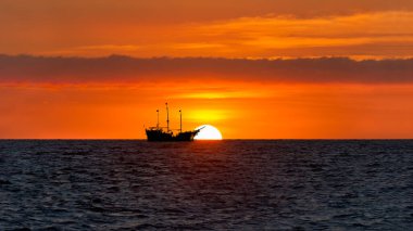 Okyanusta Bir Korsan Gemisi Renkli Turuncu Günbatımına Karşı Oturuyor