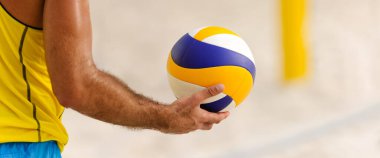 Bir voleybol oyuncusu topa yatay pankart biçiminde servis yapmaya hazırlanıyor