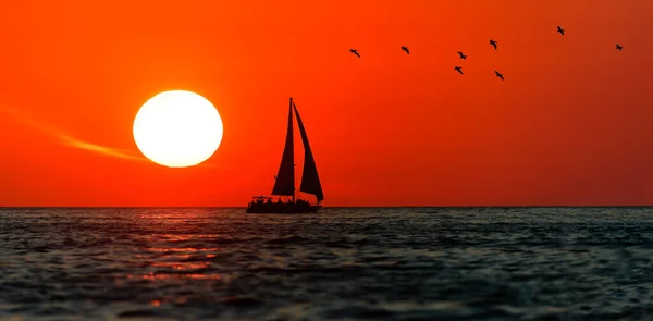 Een Zeilboot Silhouet Zeilen Tegen Een Kleurrijke Zonsondergang Hemel Een — Stockfoto
