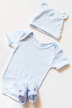 Beyaz arka planda yeni doğmuş bebek kıyafetleri, üst manzara, düz yatış.