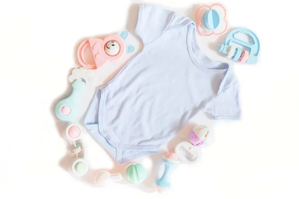 Νεογέννητα Ρούχα Μωρού Και Πολλά Πολύχρωμα Παιχνίδια Κουδουνίστρα Λευκό Φόντο — Φωτογραφία Αρχείου