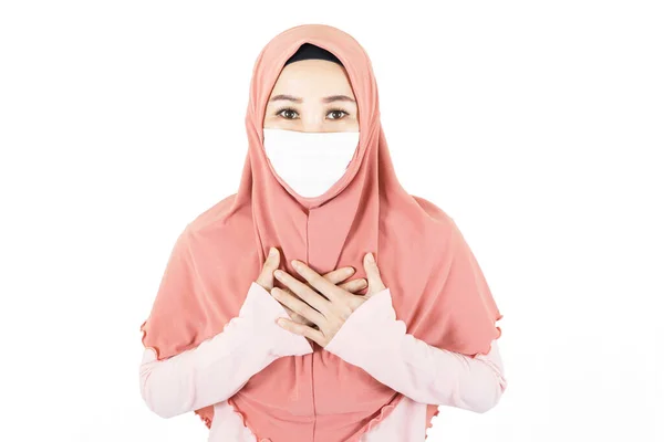 若いです美しいアジアのイスラム教徒の女性の肖像画伝統的なドレスの下で医療面マスクを身に着けていますウイルスの発生の下で 頭痛と胸が白い背景に隔離されています — ストック写真