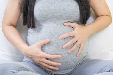 Kötü bir konsept, hamile bir kadının karın ağrısına yakın çekim. Hamilelik, annelik, sağlık, jinekoloji, ilaç kavramı. Kabızlık ve karın krampları..