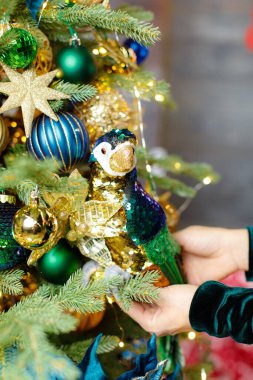 Süslü bir Noel ağacının arka planında bir kadeh şampanya tutuyor.