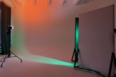 Siklonamalı boş fotoğraf stüdyosu. Renk filtrelerini kullanarak parlayan monobloclar. Beyaz siklonamalı fotoğraf stüdyosu alanı