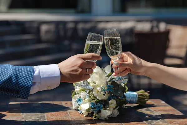 新娘和新郎用香槟酒碰杯 图库图片