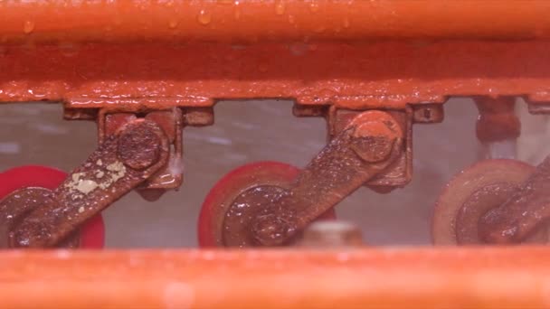 Sluiten shot van oranje kleur machine spatten water in een fabriek Slow Motion — Stockvideo