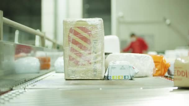 Zavřít záběr poštovních balíků pohybujících se na pásu v poštovním zařízení — Stock video