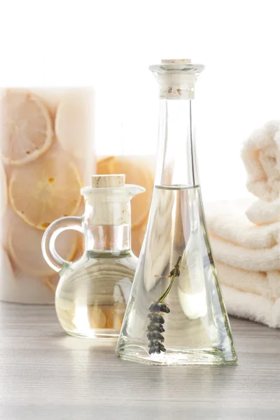 Lavender massage oils with orange candles — Stock Photo, Image