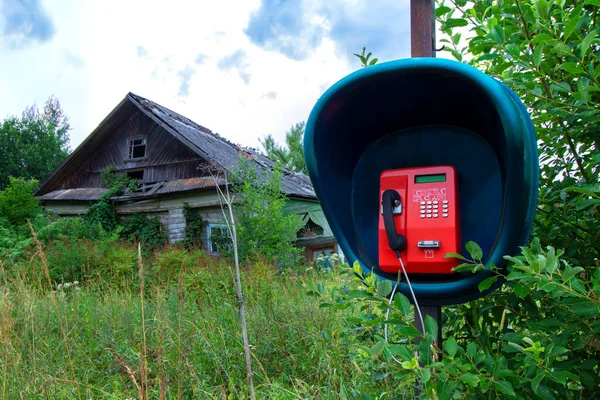 Nowoczesna Czerwona Budka Telefoniczna Tle Starego Opuszczonego Drewnianego Wiejskiego Domu — Zdjęcie stockowe