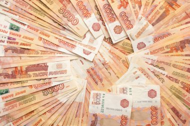 Farklı taraflardan karıştırılmış bir spiral içinde beş bin Rus rublesi var. Altüst olmuş banknotlar. Yumuşak ışık.