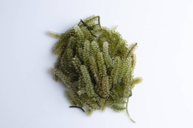 Yosun, beyaz arka planda tahta bir fincanda bir demet üzüm..