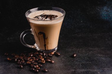 Siyah arka planda berrak bir bardakta buzlu kahve..