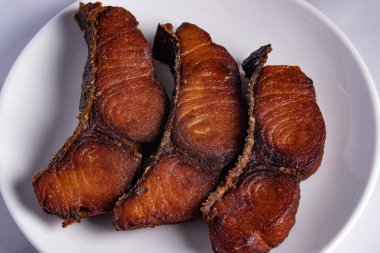 Beyaz tabakta kızarmış tuzlanmış balık.