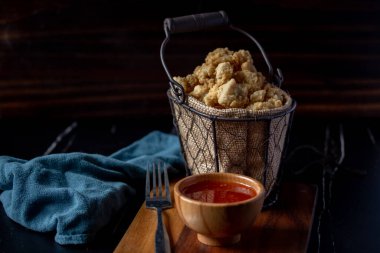 Tel sepetinde baharatlı soslu kızarmış tavuk parçaları.