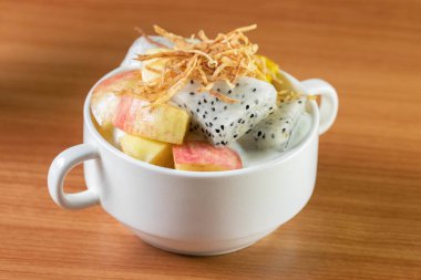 Beyaz bir fincanda karışık meyve yoğurdu.