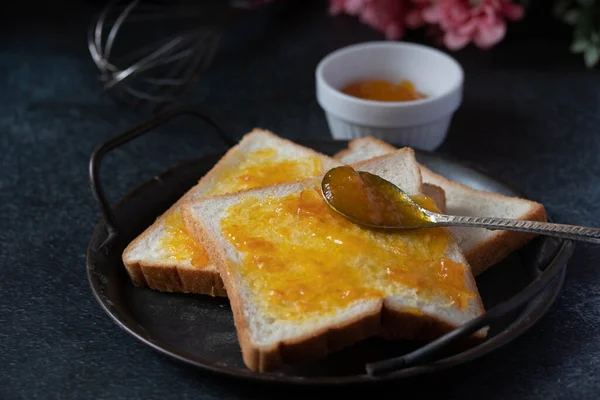 Chleb Rozłożony Pomarańczową Marmoladą Tacce Vintage Odcieniach Czerni — Zdjęcie stockowe