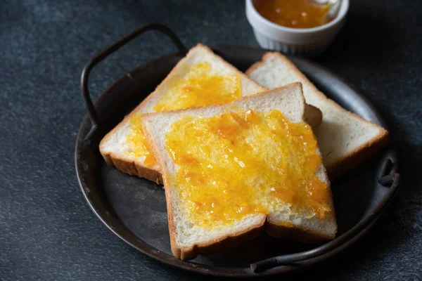 Chleb Rozłożony Pomarańczową Marmoladą Tacce Vintage Odcieniach Czerni — Zdjęcie stockowe