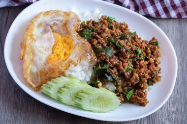 Kıyma ve sahanda yumurta ile karıştırılmış fesleğen, popüler Tayland yemeği..