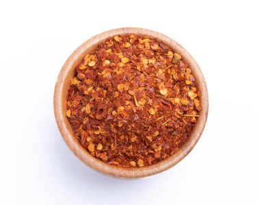 Beyaz arka planda ahşap bir fincanda kurutulmuş kırmızı biber.