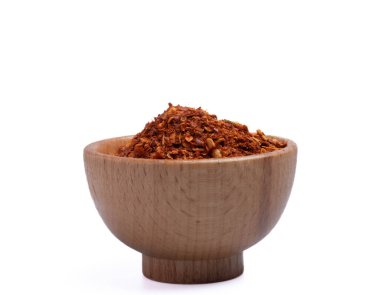 Beyaz arka planda ahşap bir fincanda kurutulmuş kırmızı biber.