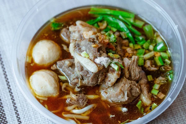 Plastik bir kapta haşlanmış domuz eti ve köfte. Yemek kutusu.