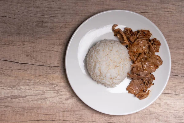 Beyaz tabakta sarımsaklı ve biberli kızarmış domuz eti.