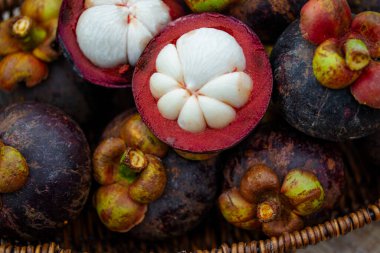 Doğal yeşil rengin arkasındaki sepette taze mangosteen..