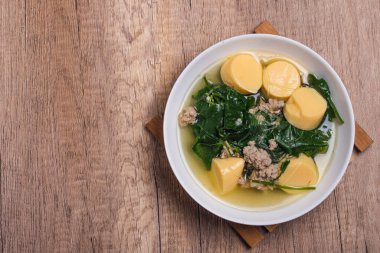 Tahta arka plandaki Tayland yemeğinin üzerinde kıymalı domuz eti ve yumurtalı tofu ile sebze çorbası. (gaeng jued tum luang)