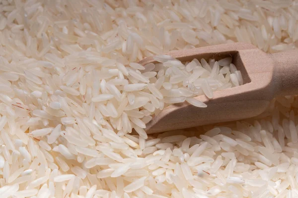 Raw rice in a wooden spoon. Thai jasmine rice.