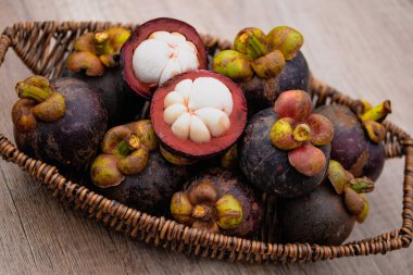 Doğal yeşil rengin arkasındaki sepette taze mangosteen..