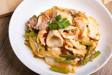 Sukiyaki ahşap arka planda beyaz kasede kurutulmuş kalamar Tayland yemeği.