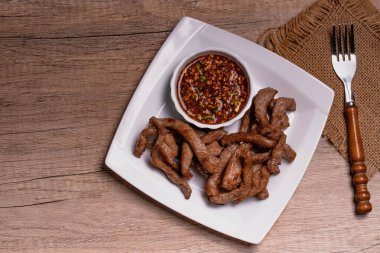 Beyaz tabakta kurutulmuş domuz eti.