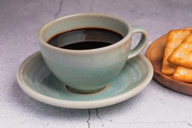 Yeşil kahve fincanında krakerli sade kahve..