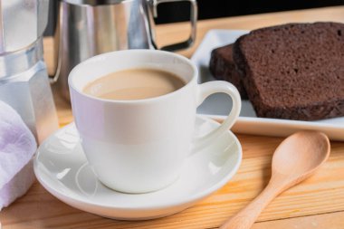 Hot coffee latte in a white coffee mug with cake.Breakfast