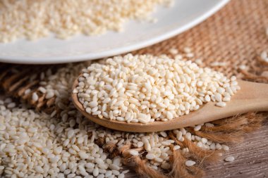 Tahta kaşıkta beyaz susam Eski ahşap arka planda