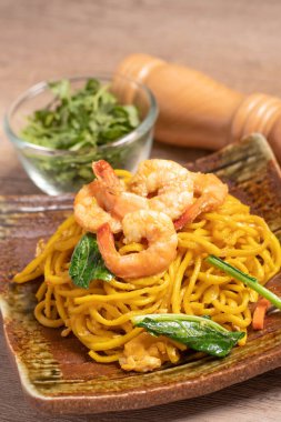 Fried noodles with shrimp in a plate on the table