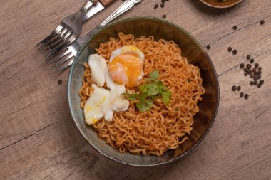 Instant noodles with boiled eggs. On wooden floor.
