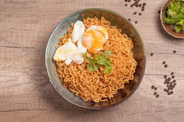 Instant noodles with boiled eggs. On wooden floor.