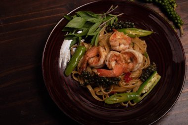 Karidesli kızarmış makarna. Arka plan koyu renk, üst manzara.