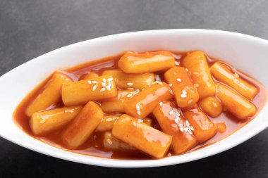 Kızarmış Kore pirinç keki tteokbokki Spicy tteokbokki Kore usulü beyaz bir fincanda.